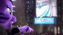 a purple cartoon character is singing in front of a crowd