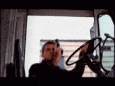 a man is holding a gun while driving a car
