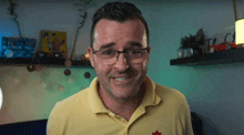 the man is wearing glasses and a yellow shirt