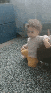 a baby is sitting on a couch on a carpet .