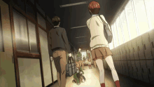 a group of people are walking down a hallway with lockers on the wall