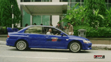 a blue car is parked in front of a building that says full on the bottom