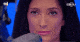 a close up of a woman 's face with the tvi logo in the corner