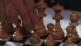a person playing a game of chess with their fingers on the pieces