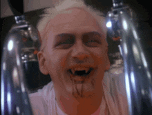 a man with blood dripping from his mouth and a white shirt