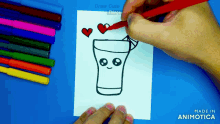a person is drawing a glass of milk with hearts around it on a piece of paper