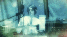 a man wearing headphones and a tie is sitting in front of a microphone