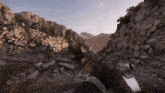 a person holding a gun in front of a rocky mountain