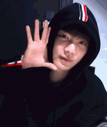 a person wearing a black hoodie with a red white and blue stripe