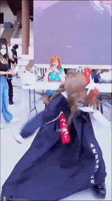 a woman wearing a mask is taking a picture of another woman wearing a mask