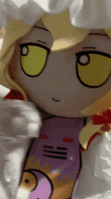 a stuffed doll with yellow eyes and a purple outfit