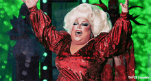 a drag queen wearing a red dress and white wig