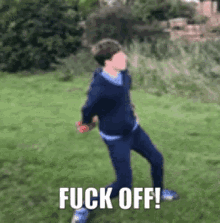 a young man is dancing in the grass with the words fuck off written on the bottom of the image .