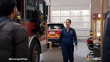 a man and a woman are standing in front of a fire truck with the hashtag #chicagofire on the bottom