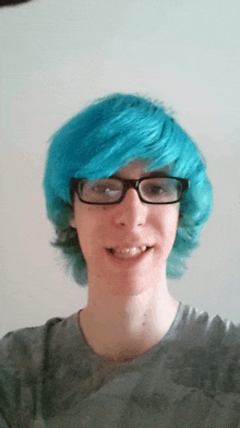 a boy with blue hair and glasses is smiling for the camera