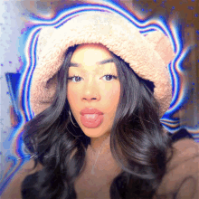 a woman sticking her tongue out wearing a bucket hat