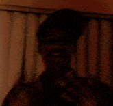 a blurry picture of a person standing in front of a window with blinds .