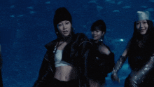 a woman wearing a white tank top and a black jacket is dancing