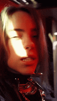 a close up of a woman 's face with red lights behind her