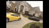 a couple of cars are driving down a driveway in front of a house .