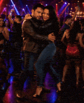 a man and a woman are hugging in a nightclub