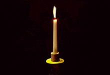a candle is lit in a yellow candle holder