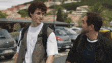 a man with a backpack talks to a young boy