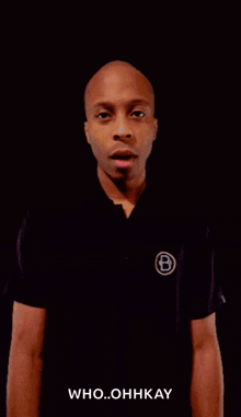 a man wearing a black shirt with the letter b on it says who ohhkay