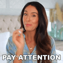 a woman says pay attention while holding a butterfly necklace