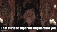 a woman in a black hat is saying that must be super fucking hard for you .