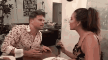 a man and a woman are sitting at a table with wine glasses .