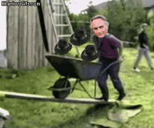 a man is pushing a wheelbarrow full of hats with hilariousgifs.com in the lower right corner