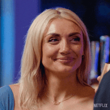 a woman wearing a necklace that says ' netflix ' on it is smiling