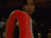 a woman is wearing a black dress and a pink fur coat