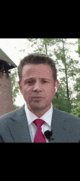 a man in a suit and tie with a microphone on his neck