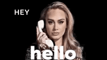 a woman is talking on a telephone with the words `` hey hello '' behind her .