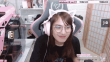 a girl wearing headphones and glasses is sitting in a chair