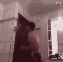 a blurry picture of a person standing in a room with a door .
