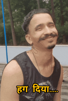 a man wearing a black tank top with a tattoo on his neck is smiling with the words hug diya written on the bottom right