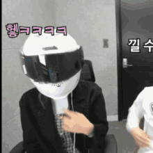 a person wearing a helmet on their head with korean writing on the wall behind them