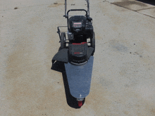 a craftsman lawn mower sits on a concrete driveway