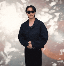 a man wearing black sunglasses and a black jacket