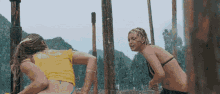 a couple of women in bikinis are standing next to each other .