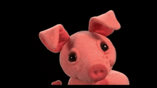 a stuffed pink pig is looking at the camera with a black background .