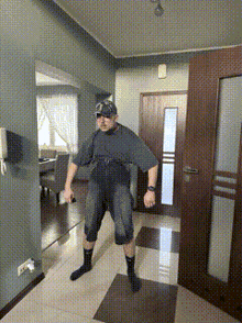 a man is standing in a hallway wearing socks and a hat