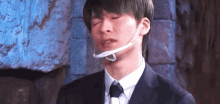 a man in a suit and tie is wearing a mask around his mouth .
