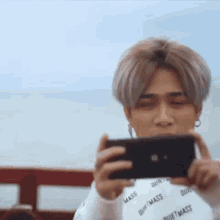 a man is taking a picture of himself with his cell phone .