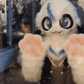 a person in a furry animal costume is waving at the camera .