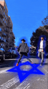 a man and a woman cross a street with a blue star in the middle