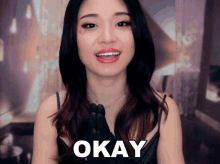 a woman with braces on her teeth says okay with her hands folded